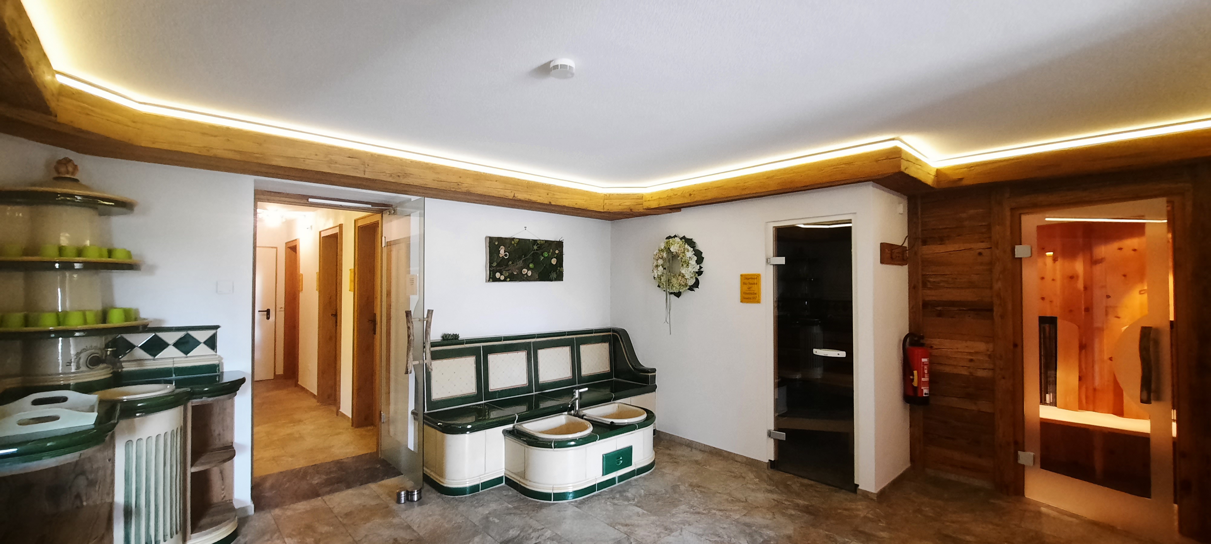 Blick im Saunabereich auf den Trinkbrunnen, die Fußbecken, die Bio-Sauna und die Infrarotkabine